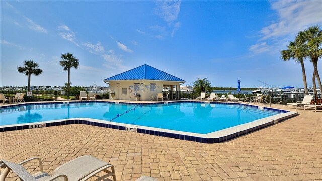 community pool featuring fence and a patio area