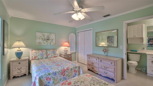 2700 N Peninsula Ave Unit 113, New Smyrna Beach, FL 32169 - bedroom with a closet, ornamental molding, connected bathroom, a ceiling fan, and baseboards
