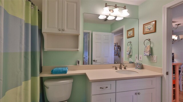 2700 N Peninsula Ave Unit 113, New Smyrna Beach, FL 32169 - bathroom featuring vanity, toilet, and a chandelier