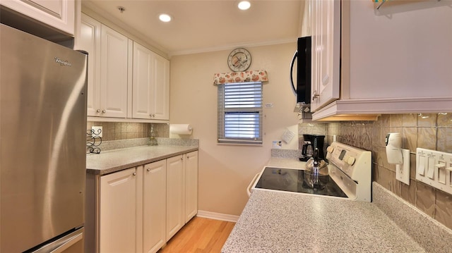 2700 N Peninsula Ave Unit 113, New Smyrna Beach, FL 32169 - kitchen with freestanding refrigerator, electric range, white cabinetry, backsplash, and recessed lighting