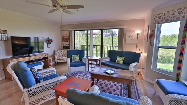 2700 N Peninsula Ave Unit 113, New Smyrna Beach, FL 32169 - living area featuring plenty of natural light, ornamental molding, a ceiling fan, light wood-style floors, and baseboards