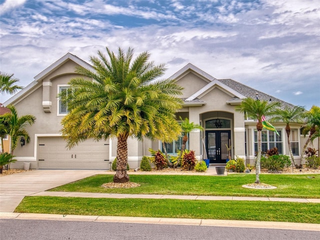 view of front of house with a front lawn, concrete driveway, stucco siding, french doors, and an attached garage