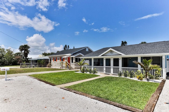 view of front of house featuring a front lawn, a porch, and a shingled roof