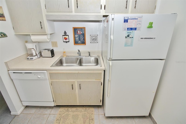 kitchen featuring a sink, baseboards, white appliances, and light countertops