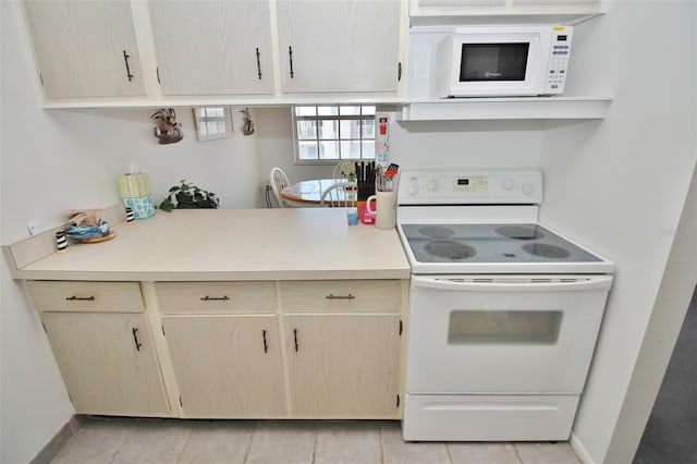 kitchen featuring baseboards, white appliances, and light countertops