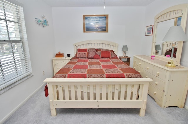 bedroom with light colored carpet and baseboards