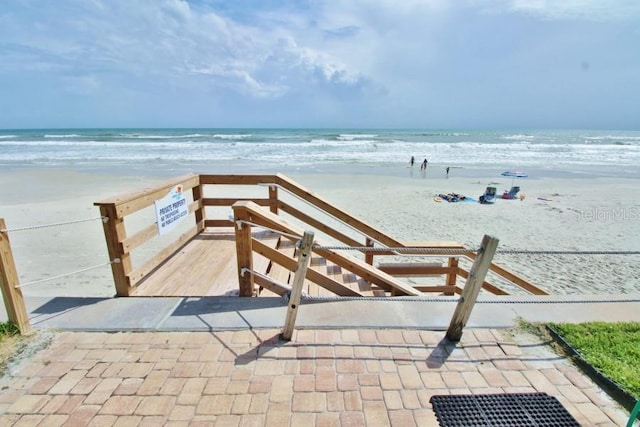 view of property's community featuring a beach view and a water view