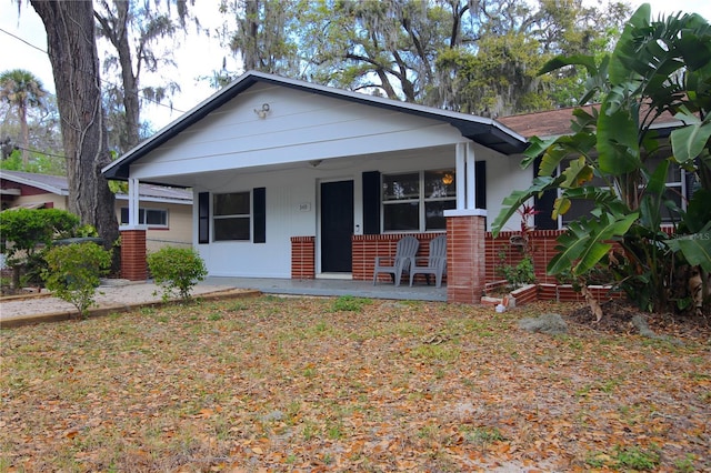 bungalow-style house with brick siding and covered porch