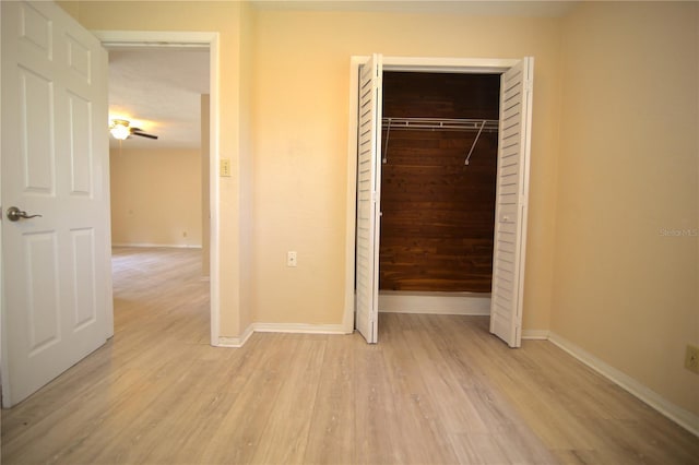 unfurnished bedroom with a closet, baseboards, and light wood finished floors