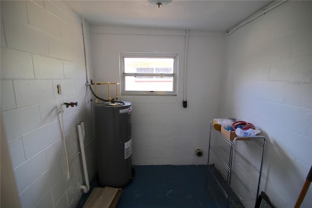 washroom featuring concrete block wall and water heater