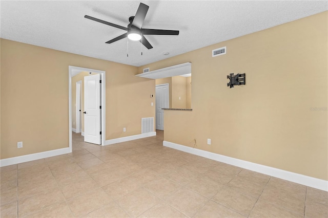 empty room with baseboards, visible vents, and a textured ceiling