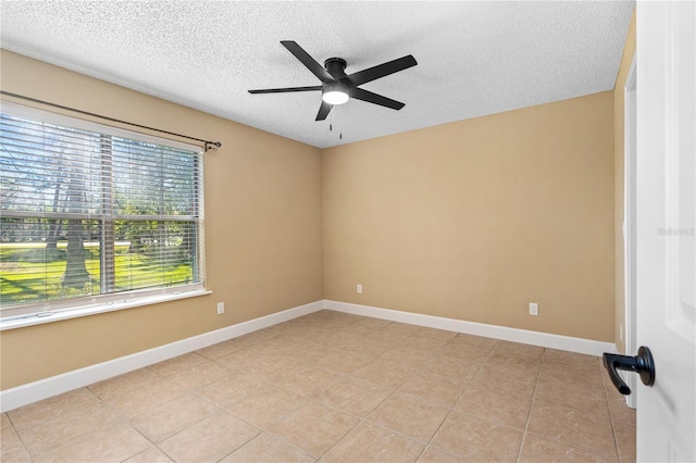 spare room featuring baseboards, a textured ceiling, ceiling fan, and light tile patterned flooring