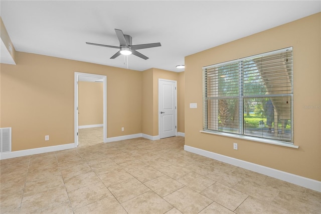 spare room featuring visible vents, baseboards, ceiling fan, and light tile patterned flooring