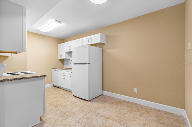 kitchen with baseboards, white appliances, and white cabinets