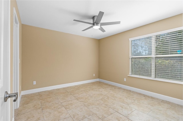 spare room featuring baseboards, ceiling fan, and light tile patterned flooring