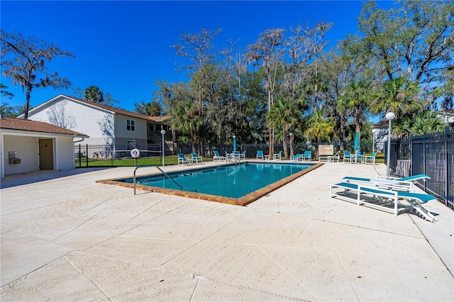 community pool featuring a patio and fence