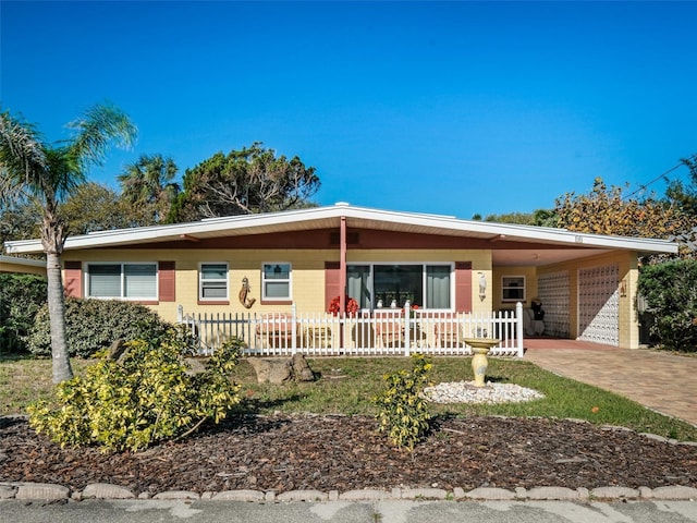 single story home with a carport, driveway, and a fenced front yard