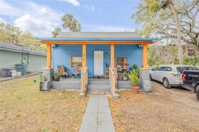 view of outdoor structure with a porch and fence