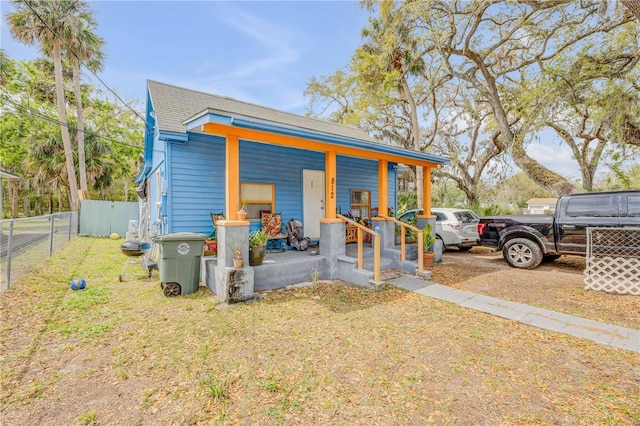 exterior space featuring covered porch and fence