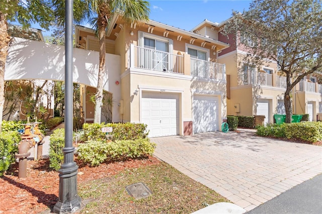 view of front of property with stucco siding, decorative driveway, and a garage