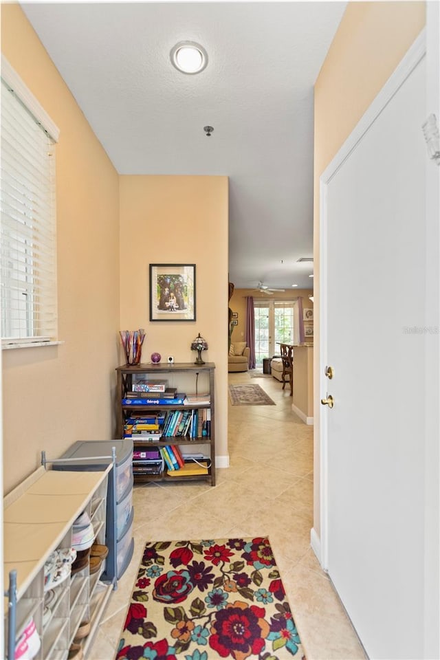 hallway with light tile patterned floors and baseboards