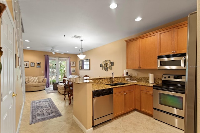 kitchen with visible vents, a sink, open floor plan, stainless steel appliances, and a peninsula