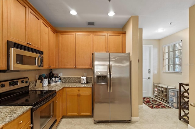 kitchen featuring brown cabinetry, light stone countertops, visible vents, recessed lighting, and stainless steel appliances