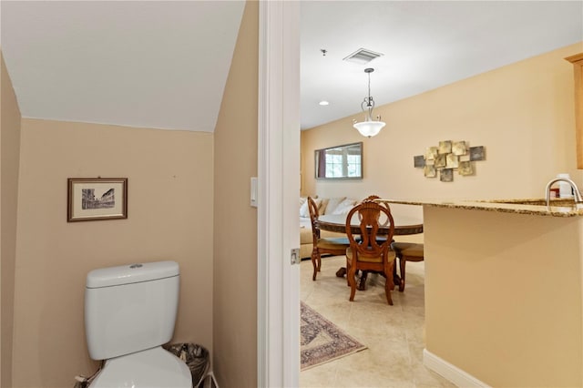 bathroom featuring baseboards, visible vents, a sink, tile patterned floors, and toilet