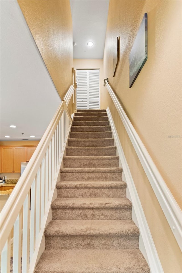 stairs featuring carpet and recessed lighting