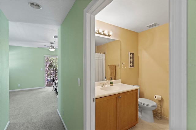 bathroom with visible vents, baseboards, ceiling fan, toilet, and vanity