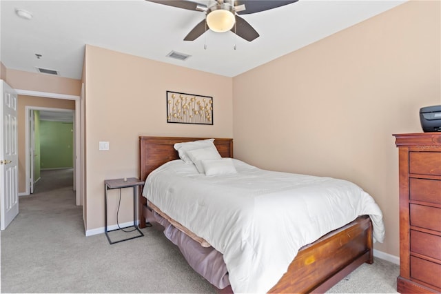 bedroom with ceiling fan, light colored carpet, visible vents, and baseboards