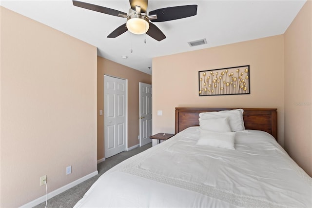 carpeted bedroom with visible vents, baseboards, and a ceiling fan