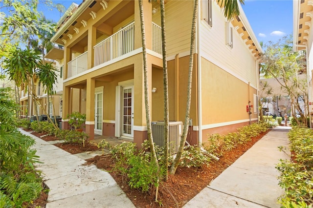 view of side of property featuring central air condition unit and stucco siding