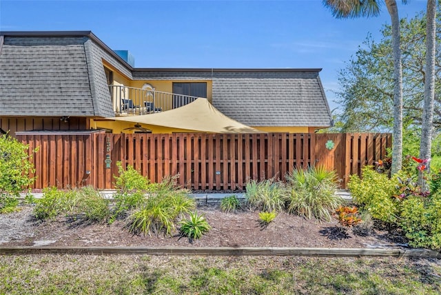 view of yard with a balcony and fence