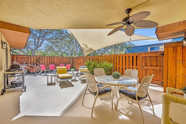 view of patio / terrace featuring outdoor dining area, a fenced backyard, and a ceiling fan