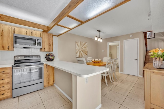 135 Cedar Dunes Dr, New Smyrna Beach, FL 32169 - kitchen featuring decorative backsplash, a peninsula, light countertops, appliances with stainless steel finishes, and light tile patterned floors