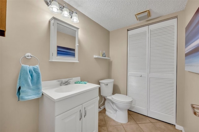 135 Cedar Dunes Dr, New Smyrna Beach, FL 32169 - bathroom with a textured ceiling, tile patterned flooring, vanity, a closet, and toilet