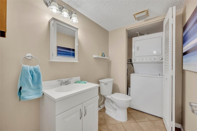 135 Cedar Dunes Dr, New Smyrna Beach, FL 32169 - bathroom with vanity, tile patterned flooring, visible vents, stacked washer / dryer, and toilet