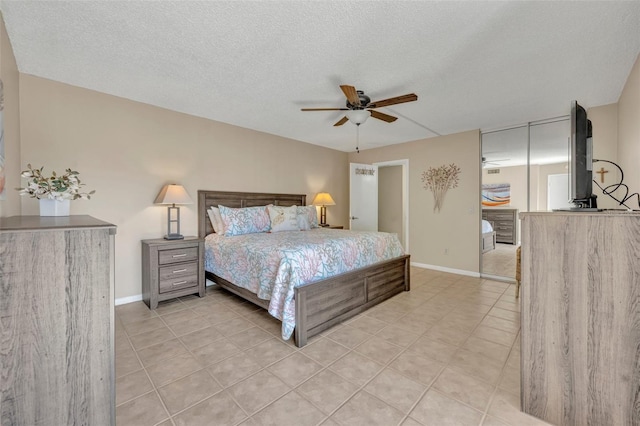 135 Cedar Dunes Dr, New Smyrna Beach, FL 32169 - bedroom featuring light tile patterned floors, baseboards, a ceiling fan, and a textured ceiling