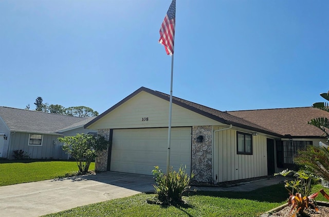 exterior space featuring a front lawn, roof with shingles, driveway, stone siding, and an attached garage