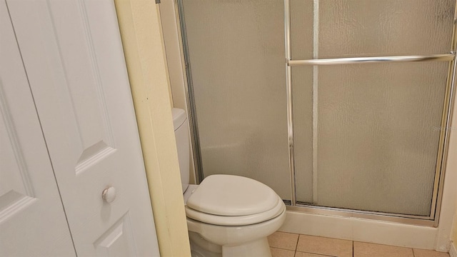 full bath with tile patterned floors, toilet, and a stall shower