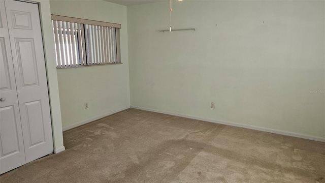 carpeted spare room featuring baseboards