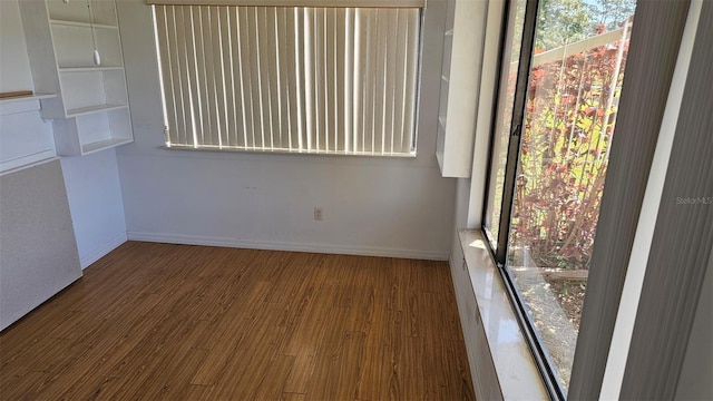 empty room featuring wood finished floors and baseboards