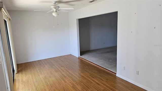 unfurnished room featuring visible vents, wood finished floors, baseboards, and ceiling fan