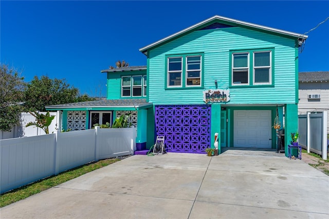 view of front facade with fence, a garage, and driveway