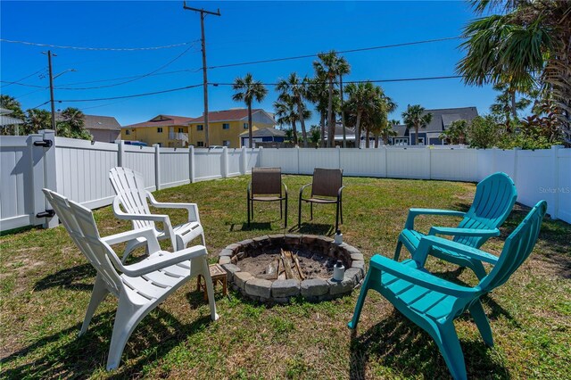 view of yard with a residential view, an outdoor fire pit, and a fenced backyard