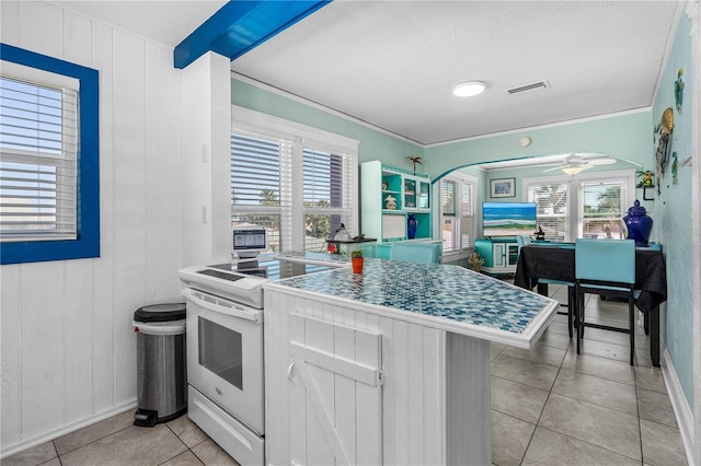 kitchen with visible vents, arched walkways, a healthy amount of sunlight, and white range with electric cooktop