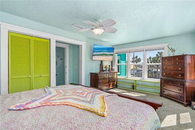 carpeted bedroom featuring visible vents, a closet, and ceiling fan