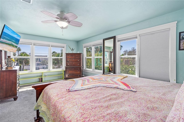 carpeted bedroom with a ceiling fan and a textured ceiling