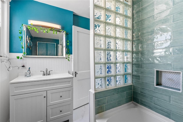 bathroom with a bathing tub, vanity, and walk in shower